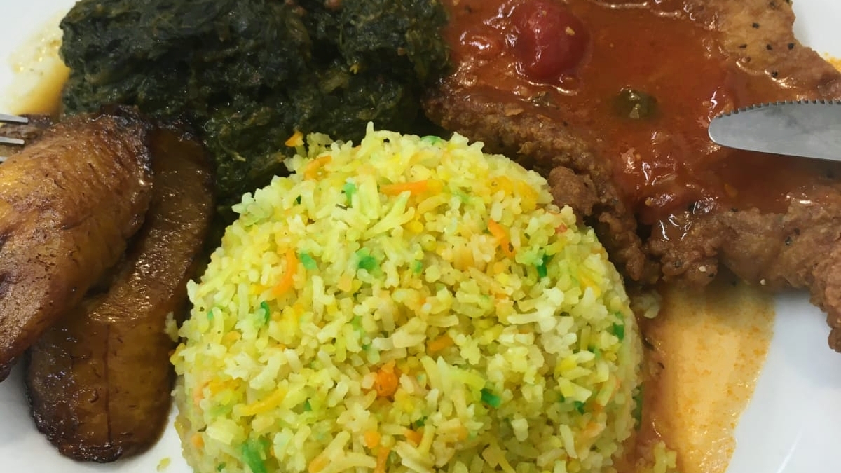A Guyanese plate of seasoned rice, stew chicken, fried plantain and callaloo at Kaieteur Kitchen